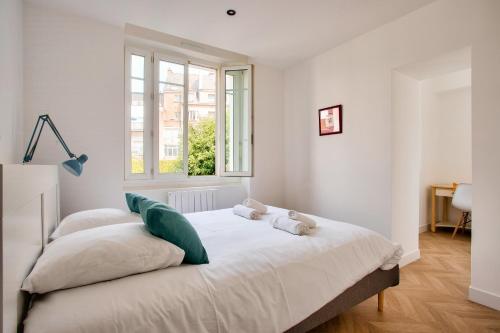 - une chambre blanche avec un lit et deux oreillers dans l'établissement Doux séjour à Nantes, à Nantes