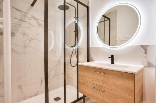 La salle de bains est pourvue d'une douche, d'un lavabo et d'un miroir. dans l'établissement Doux séjour à Nantes, à Nantes