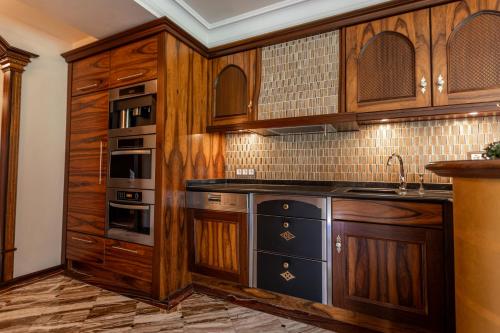 a kitchen with wooden cabinets and a sink at FOR MOMENTS Apartments & Spa in Roßhaupten