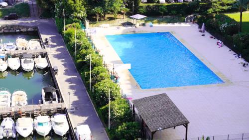 - une vue sur la grande piscine avec des bateaux dans l'établissement Cannes Marina, T3 vue Mer, Piscine, By Palmazur, à Mandelieu-la-Napoule