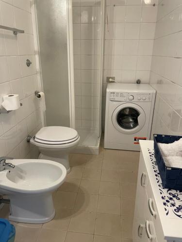 een badkamer met een toilet en een wasmachine bij Casa Vacanze Primavera in Maratea