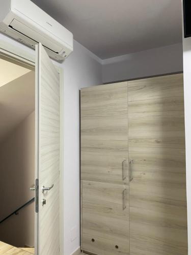 Schlafzimmer mit einem Schrank und einer großen Holztür in der Unterkunft La casa dell’Aurora in Falcone