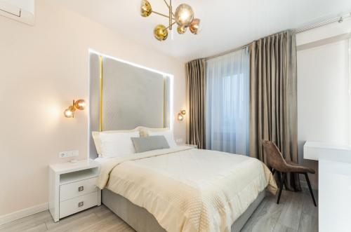 a white bedroom with a bed and a window at Great Apartment 1 in Chişinău
