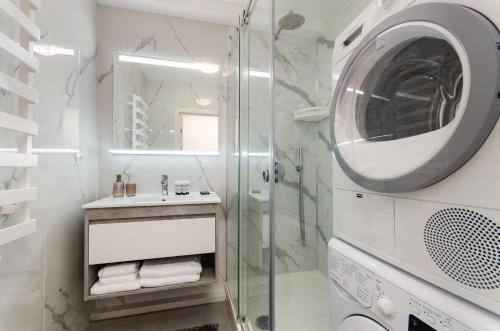a bathroom with a shower and a washing machine at Great Apartment 1 in Chişinău