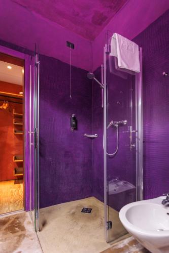 a purple bathroom with a shower and a sink at Ambienthotel PrimaLuna 3S in Malcesine