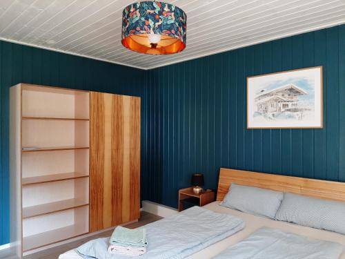 ein Schlafzimmer mit einem Bett und einer blauen Wand in der Unterkunft Annemarie Zerpenschleuse - Schwedenhaus mit Künstler-Charme und Sauna in Zerpenschleuse