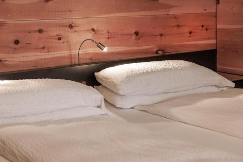 two white pillows sitting on top of a bed at Ambienthotel PrimaLuna 3S in Malcesine