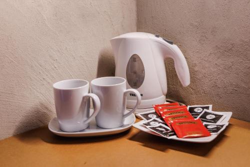 two coffee cups on a table next to a blender at Ambienthotel PrimaLuna 3S in Malcesine