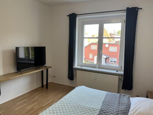a bedroom with a bed and a tv and a window at Apartment 2 - Haus Lausitzring in Annahütte