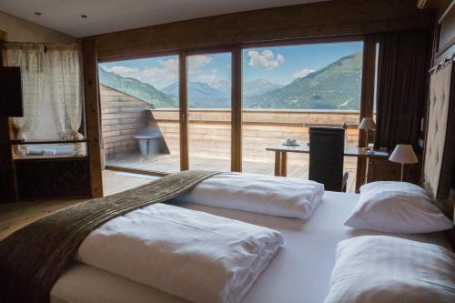 two beds in a room with a large window at Wellness Aparthotel Panorama Alpin - Ferienwohnungen Jerzens im Pitztal in Jerzens