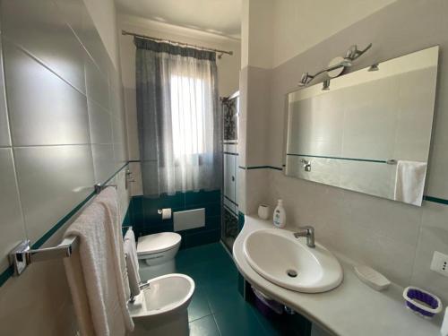 een badkamer met een witte wastafel en een toilet bij Casa Diamante in San Vito lo Capo
