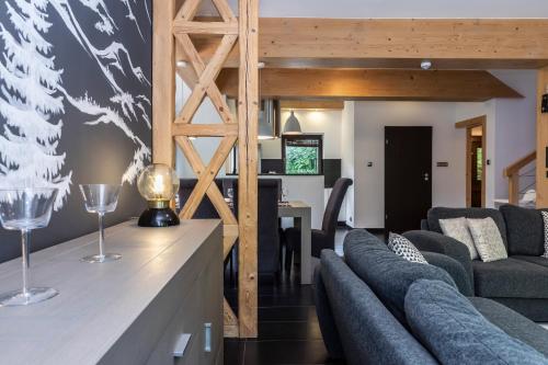 a living room with two couches and a table at TatryTop Alpejski SPA in Kościelisko