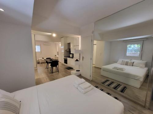 a white bedroom with a bed and a dining room at Apartment Near The Center Of Glyfada in Athens