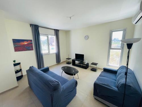 a living room with a blue couch and a table at City Center Cozy Apt in Paphos City