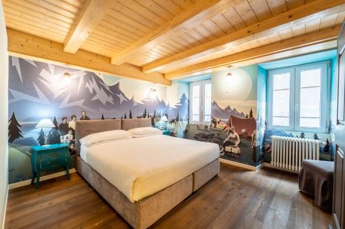 een slaapkamer met een bed met een muurschildering van de bergen bij B&B Nonna Costantina in Chiavenna