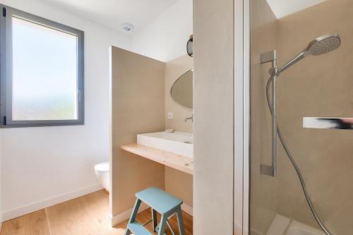 a bathroom with a shower and a blue stool at Villa d'architecte avec Piscine chauffée et jardin in Rivedoux-Plage