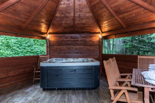 a sauna with a tub in a wooden cabin at TatryTop Alpejski SPA in Kościelisko