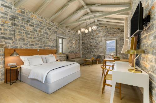 una camera con un letto in un muro di mattoni di Trapela Limeni Luxury Suites a Limeni