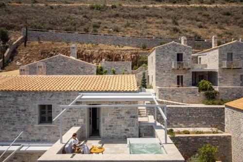a man sitting on the roof of a house at Trapela Limeni Luxury Suites in Limeni