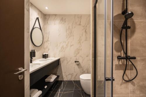 a bathroom with a shower and a toilet and a sink at The Ebrington Hotel in Derry Londonderry