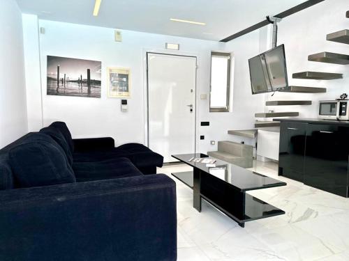 a living room with a couch and a tv at LeBlanc Luxurious Beachfront Villa by Goutos Luxury Living in Ermioni