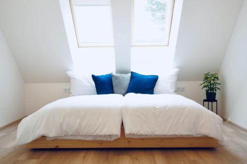 a bedroom with a white bed with blue pillows at Jiná báseň in Pustá Rybná