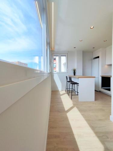 a kitchen and dining room with white walls and a large window at Aljarafe Central Square - by Pro Apartments in San Juan de Aznalfarache