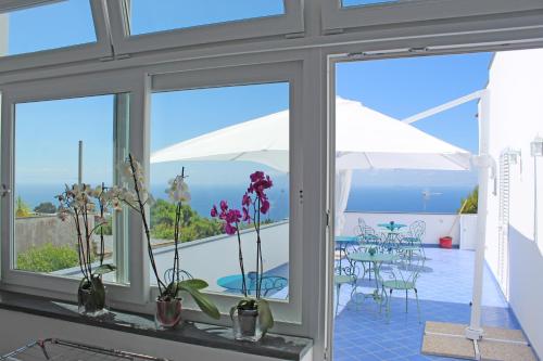 a room with windows and a view of the ocean at B&B Casa Angelina in Anacapri