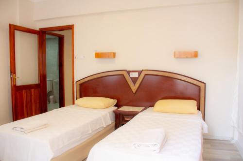 two beds in a room with white sheets and yellow pillows at Alanya Luxury apart in Alanya