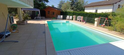 a swimming pool in a yard next to a house at Chez les Michel in Viry