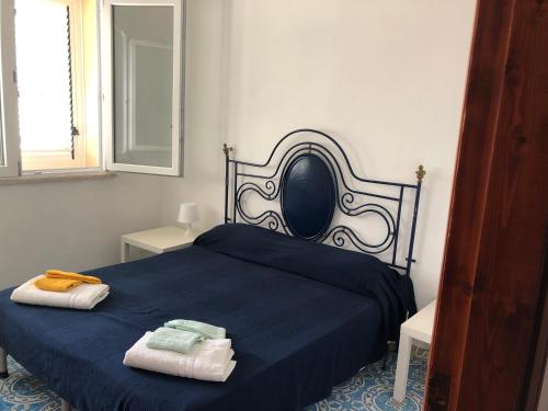 a bedroom with a blue bed with towels on it at Villa Panoramica in Valderice