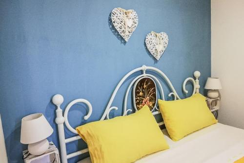 una camera da letto con un letto bianco con cuori appesi al muro di Casal Sirio a San Mauro Cilento