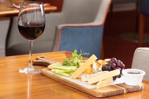 a glass of wine and a plate of cheese and vegetables at The Beaches Hotel and Spa in Prestatyn