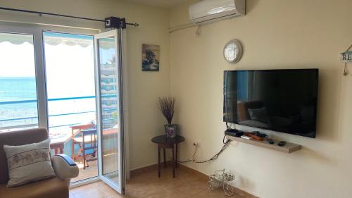 a living room with a flat screen tv on the wall at Anxhelo's Apartment in Shëngjin