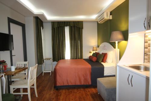 um quarto de hotel com uma cama e uma cozinha em Hotel Taksim Home em Istambul