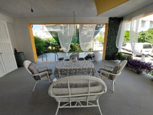 een patio met een tafel en stoelen en een tafel en stoelen bij Oranje Guesthouse in Itea