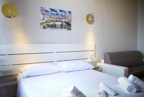 ein Schlafzimmer mit einem weißen Bett und einem Stuhl in der Unterkunft IL MERCATO CENTRALE B and B in Florenz