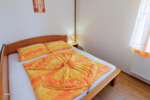 Un dormitorio con una cama con una manta amarilla. en Penzion Zvoneček, en Jetřichovice