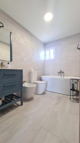 a bathroom with two toilets and a tub and a sink at Vacaciones de ensueño in Mojácar