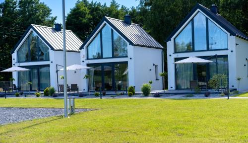 a large white house with glass windows and umbrellas at Bałtyckie Zacisze Kopalino in Kopalino