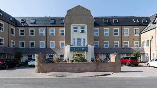 un estacionamiento frente a un gran edificio en The Beaches Hotel, en Prestatyn