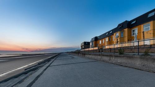 an empty road next to a building on the beach at The Beaches Hotel and Spa in Prestatyn