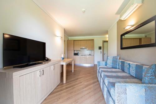 a living room with a couch and a flat screen tv at Lake Garda Resort in Moniga