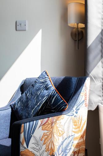 a couch with a pillow on top of it at The Beaches Hotel and Spa in Prestatyn