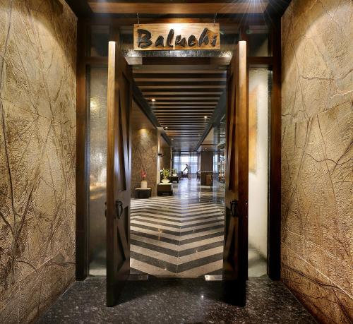 a hallway leading to a lobby with a door at The LaLiT New Delhi in New Delhi