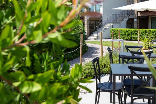 a row of tables and chairs with umbrellas at Lake Garda Resort in Moniga