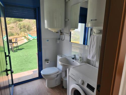 een badkamer met een toilet, een wastafel en een raam bij VILLA GABRIEL in Canillas de Albaida