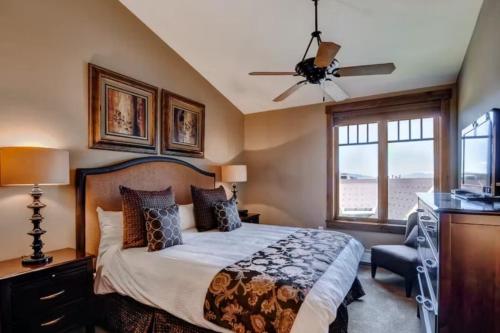 布雷肯里奇3 Bedroom Mountain Condo On Main Street - Walk To Lift, Onsite Pool, Luxury-Rated!的一间卧室配有一张带吊扇和窗户的床。