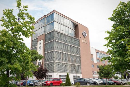 a building with cars parked in front of it at Košice Hotel in Košice