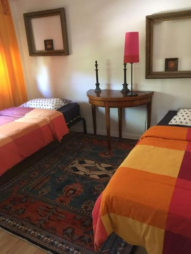 Cette chambre comprend 2 lits, une table et un tapis. dans l'établissement maison de campagne, à Reignier-Ésery